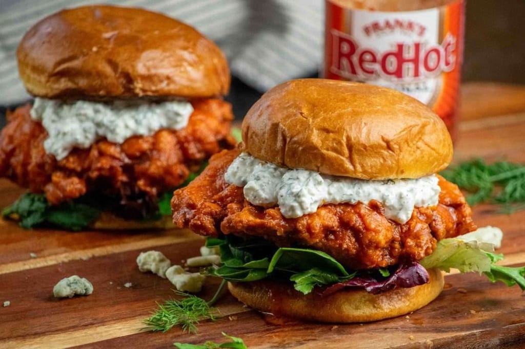 Crispy buffalo chicken sandwich with pickles and creamy slaw on a toasted bun